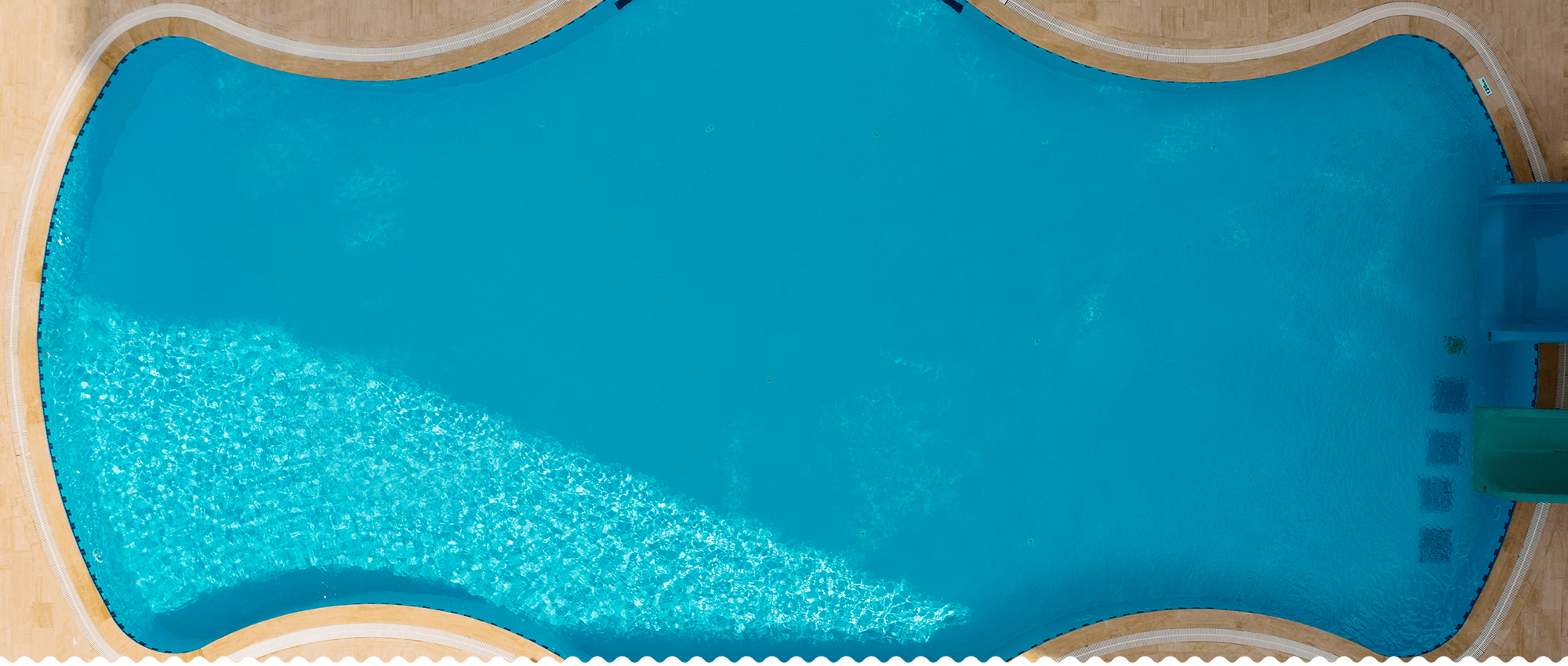 Clear swimming pool water and poolside paving